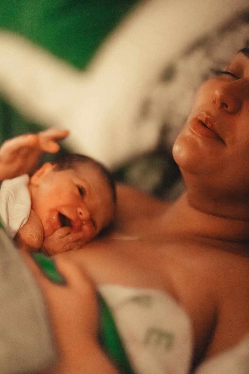 Alexis Downs lays with her son, Theo, shortly after giving birth at home.