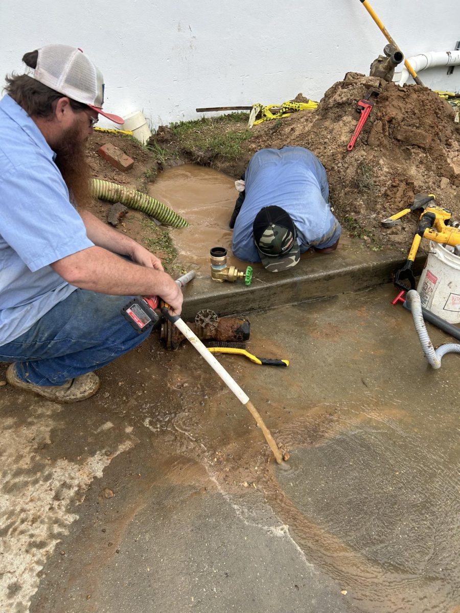 Poplarville public works employees pump water out of their workspace as they installed a new water meter. 