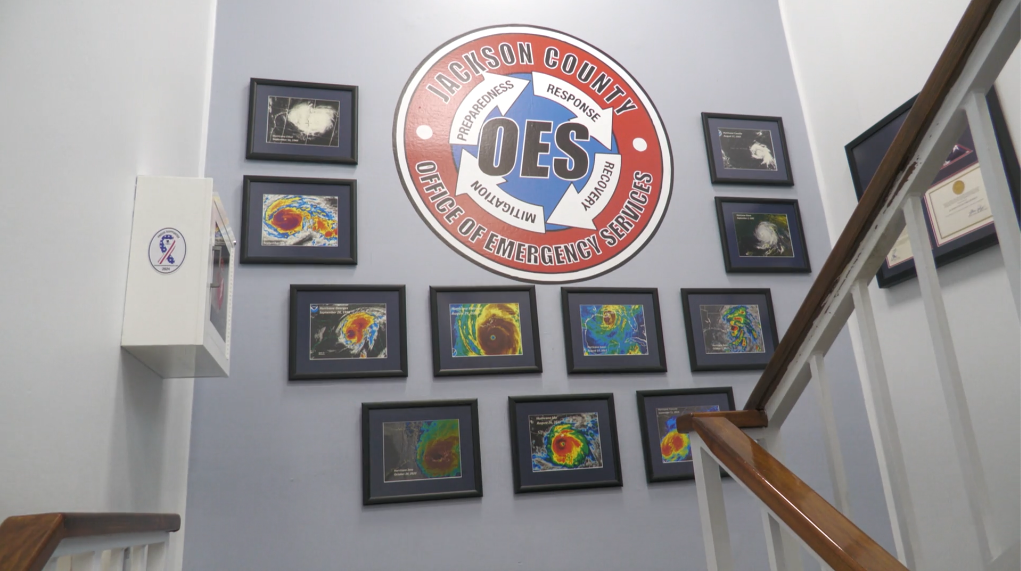 The Jackson County Office of Emergency Services displays satellite images of past hurricanes on its wall. (RHCJC News)