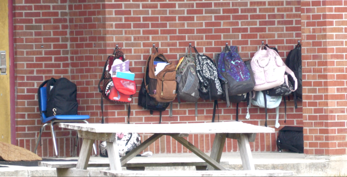 Students' bookbags hanging up outside of school building. (RHCJC).