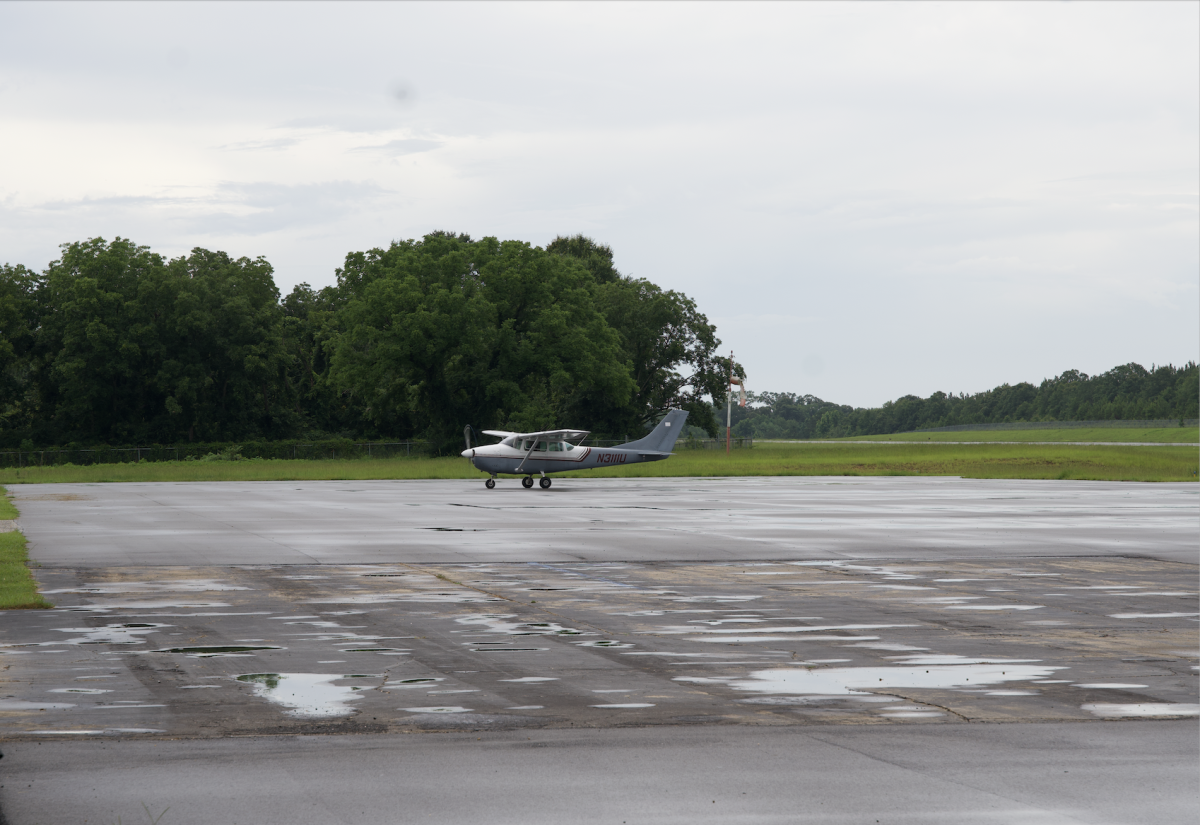 A small aircraft taxis across the wet runway at the Poplarville–Pearl River County Airport following rain. The airport plans to add new hangars using federal funds.