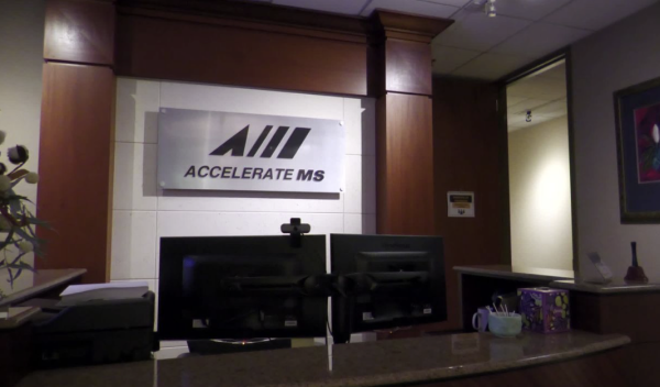 Reception area at the AccelerateMS workforce development office, featuring two computer monitors and a sign reading “Accelerate MS.”