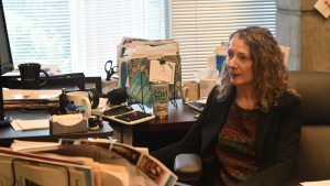 Sarah Ruskey sits at her desk in front of a computer, speaking about the Harrison County Library System’s mobile outreach efforts.