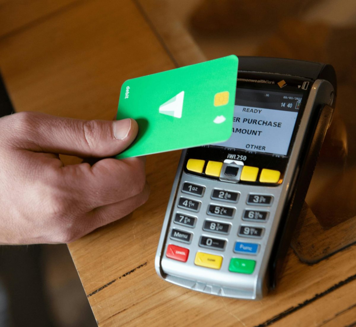 A customer uses a contactless debit card at a point-of-sale terminal in this undated file photo. A “What Is True?” investigation by the Roy Howard Community Journalism Center found that criminals do use skimmers to steal card data at gas pumps and ATMs — often placing the devices inside the machines. However, the team rated as false the claim that RFID scanners can steal credit card information from 15 to 20 feet away. Experts say contactless cards are encrypted and not vulnerable to long-distance scanning.