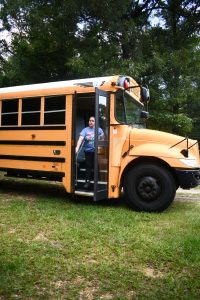 A woman steps off a school bus.