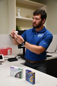 Veterinarian holding a bottle of preserved heartworms and discussing prevention medications.