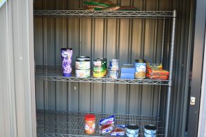 A metal pantry holds cans, noodles and peanut butter outside a building in Hattiesburg.