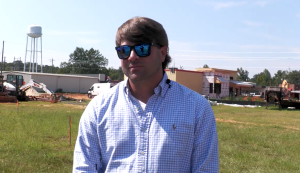 Dylan McInnis, Greene County Board of Supervisors District 1, standing outdoors with construction site in the background.