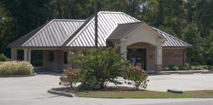 A brick office building with a brown metal roof with the words “North Lamar Water Association” on the wall.