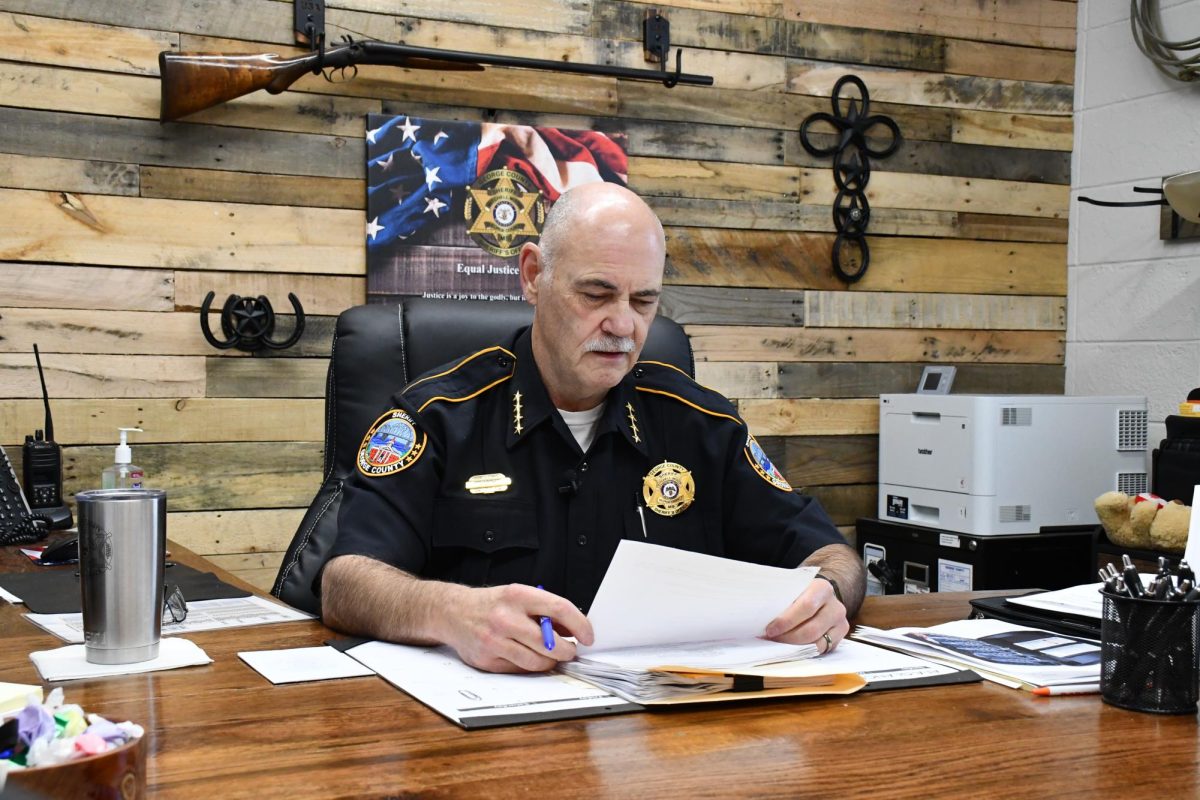 George County Sheriff Mitchell Mixon sits at his desk reviewing paperwork in his office.