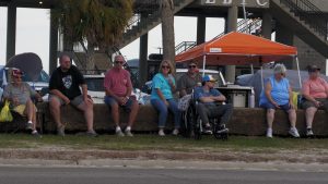 Spectators line a Long Beach street, taking photos and watching classic cars pass during the Cruisin’ the Coast parade.