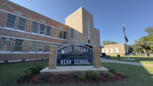 Exterior of Moss Point High School, a brick building with a sign out front.