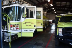 Green Lamar County fire engine parked inside a fire station bay.