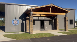 Exterior of the Greene County Emergency Management building in Leakesville, Mississippi, with a stone and metal facade and the county seal on the wall.