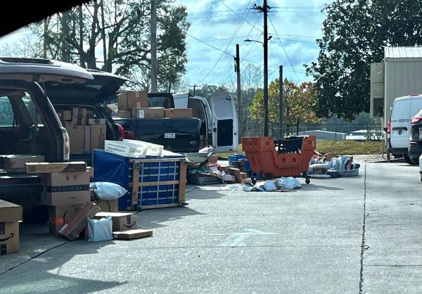Dozens of packages are scattered across the ground and are packed into the open vehicles.