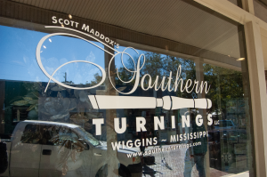 The Southern Turnings logo and name appear on a storefront window reflecting the street outside.