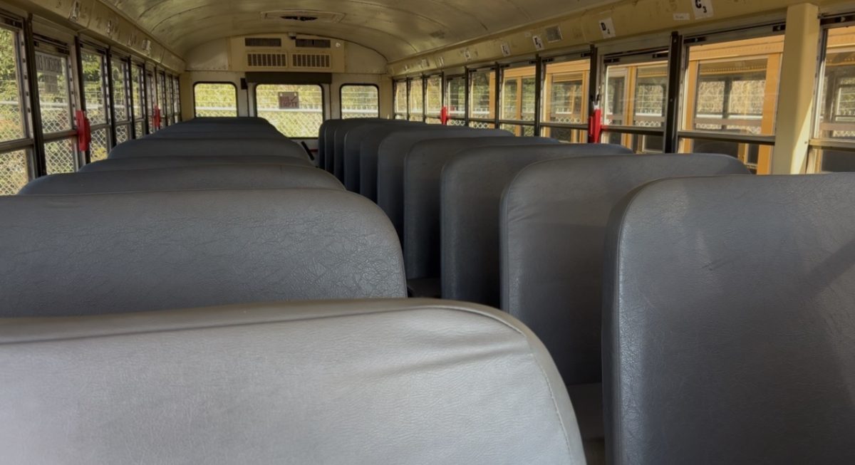 Rows of empty seats inside a school bus.