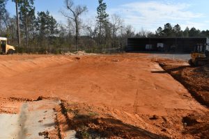 A dirt area that has been leveled to prepare for the concrete pad.
