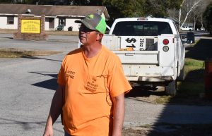 Scott Extine, wearing an orange shirt and cap, stands outside New Augusta Town Hall while discussing sewer repairs and plans for a new lift station.
