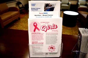 Brochures about breast cancer screening, prevention and nutrition sit on a display rack in a waiting area.