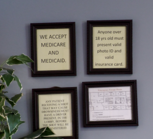 Four framed signs on a wall at Southern Medical Care explain office policies, including accepted insurance, photo ID requirements, and the need for a driver for some procedures.