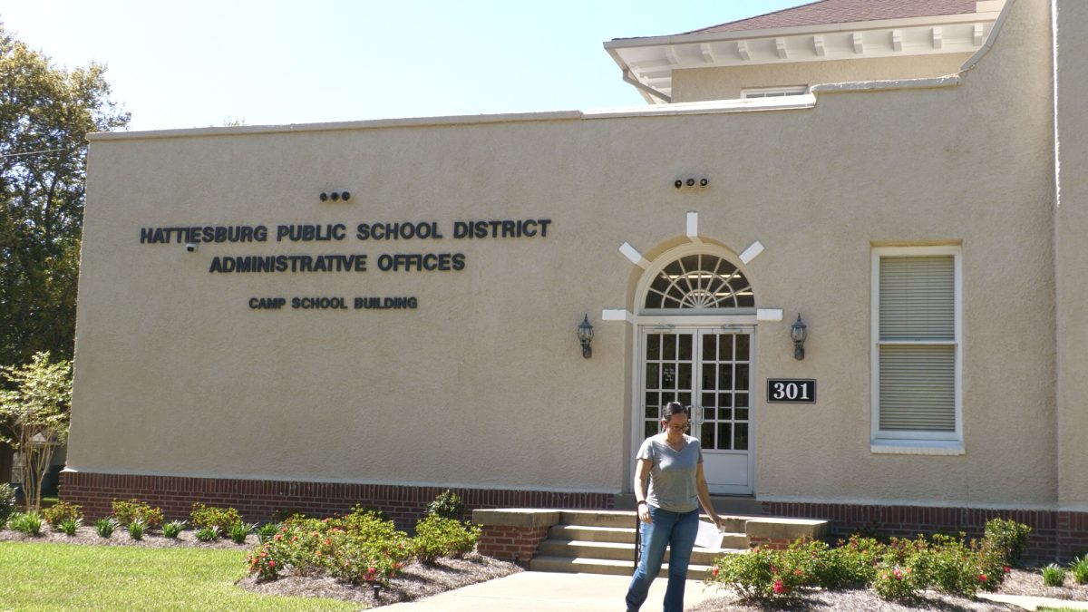 The exterior of the Hattiesburg Public School District administrative offices, with a person walking near the entrance.