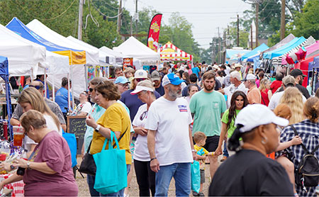 Crowds browse vendor booths and festival tents during the Pine Hill Festival in downtown Wiggins, Mississippi.
