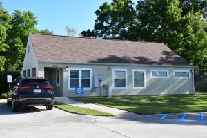 The Bethel Free Health Clinic building at Suncoast Villas with a car parked outside.