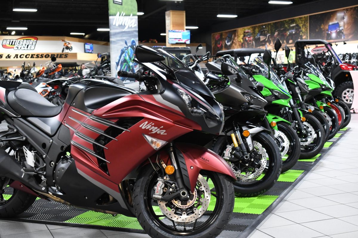 A row of motorcycles is displayed at Hattiesburg Cycles, with a red and black motorcycle in front.