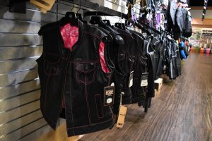 Black motorcycle vests hang on display at Hattiesburg Cycles.