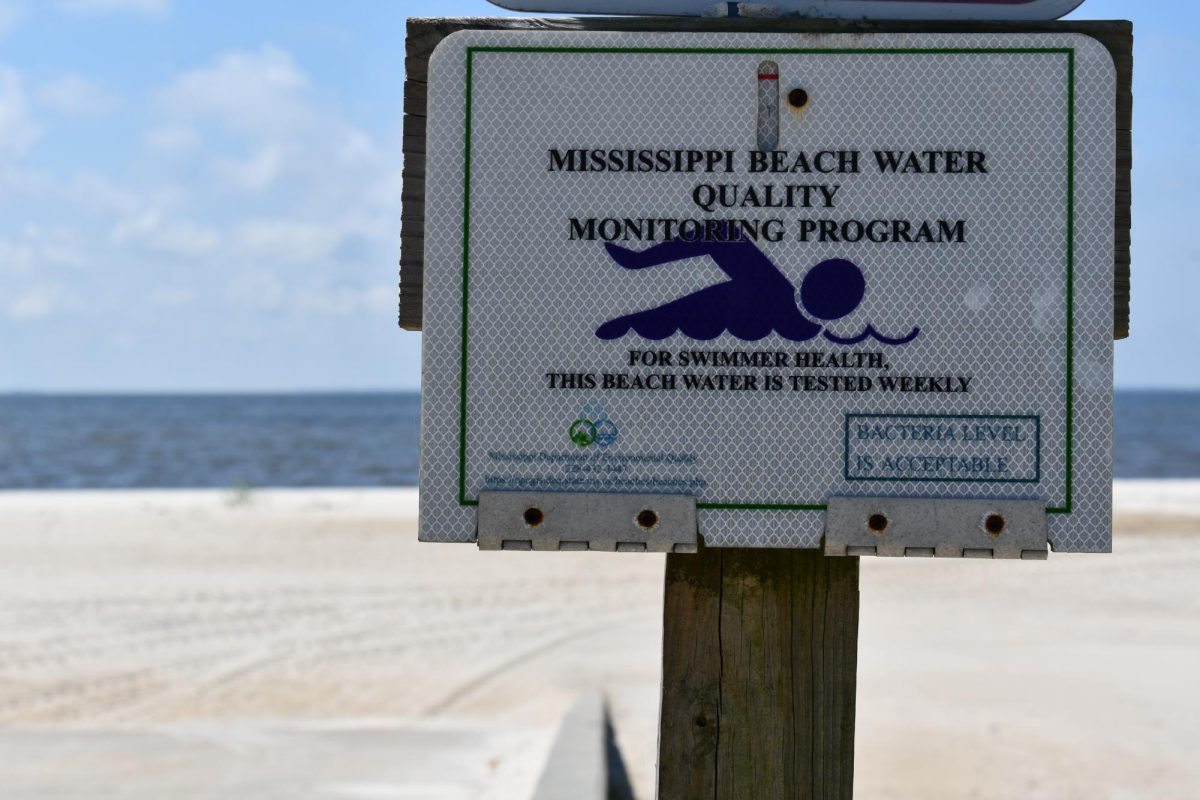 A sign on the beach informs visitors that water quality is tested regularly.