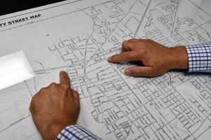 Close-up of two hands pointing to locations on a printed city street map.