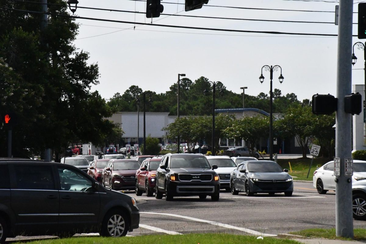 Traffic backed up at the intersection of Mallett Road and Lamey Bridge Road in D'Iberville, with multiple vehicles waiting at a traffic light.